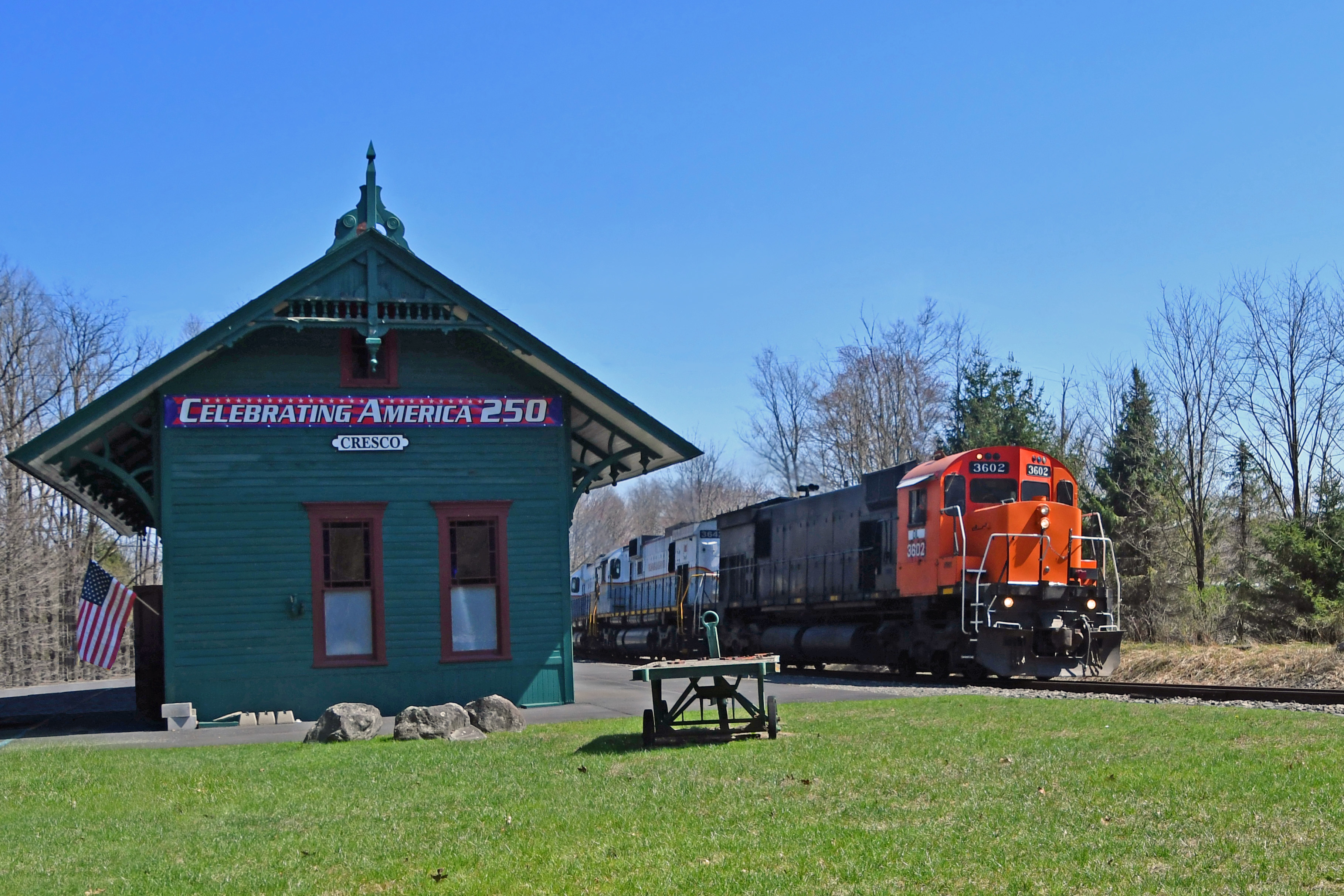 This photo features a train locomotive at the historic Cresco Train Station. It is surrounded by beautiful Poconos foliage.