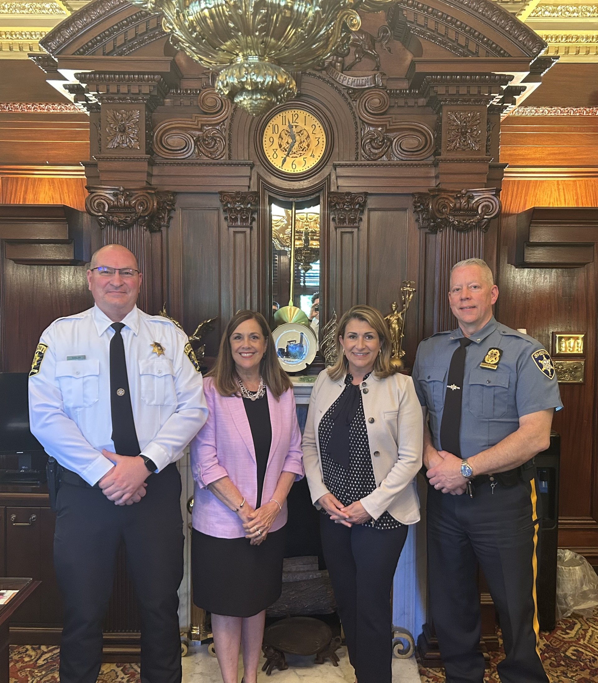 Sen. Brown stands with Wayne County Sheriff Chris Rosler, Senator Lisa Baker, and Pike County Sheriff Brian Vennie in Senator Baker’s Harrisburg office, with a large grandfather clock in the background.