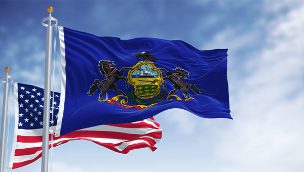 the PA flag and American flag waving in wind