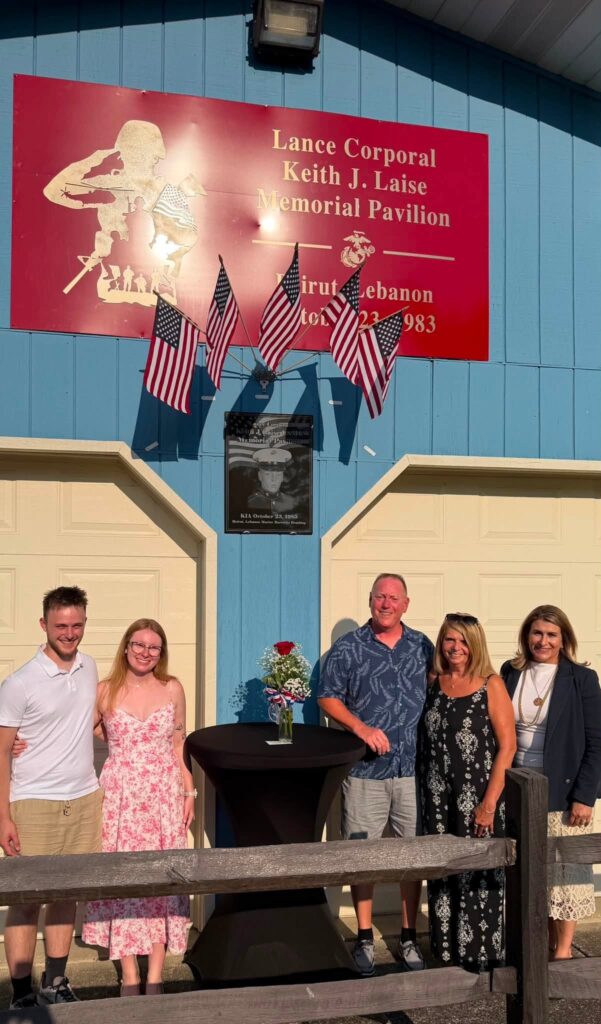 Sen. Rosemary Brown poses in front of the sign for Lance Corporal Keith J. Laise and his family at the American Legion Post 346.