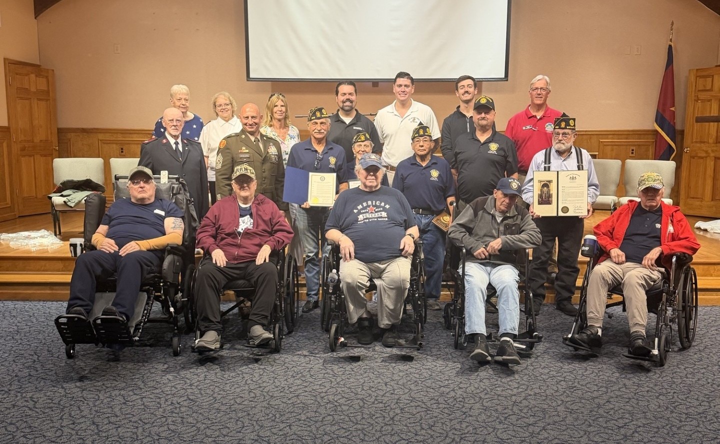 A large group of veterans and local officials pose for a picture inside the chapel of the Ladore Retreat and Conference Center. Brooks from Senator Brown’s staff presented the green citation to American Legion Post 889.