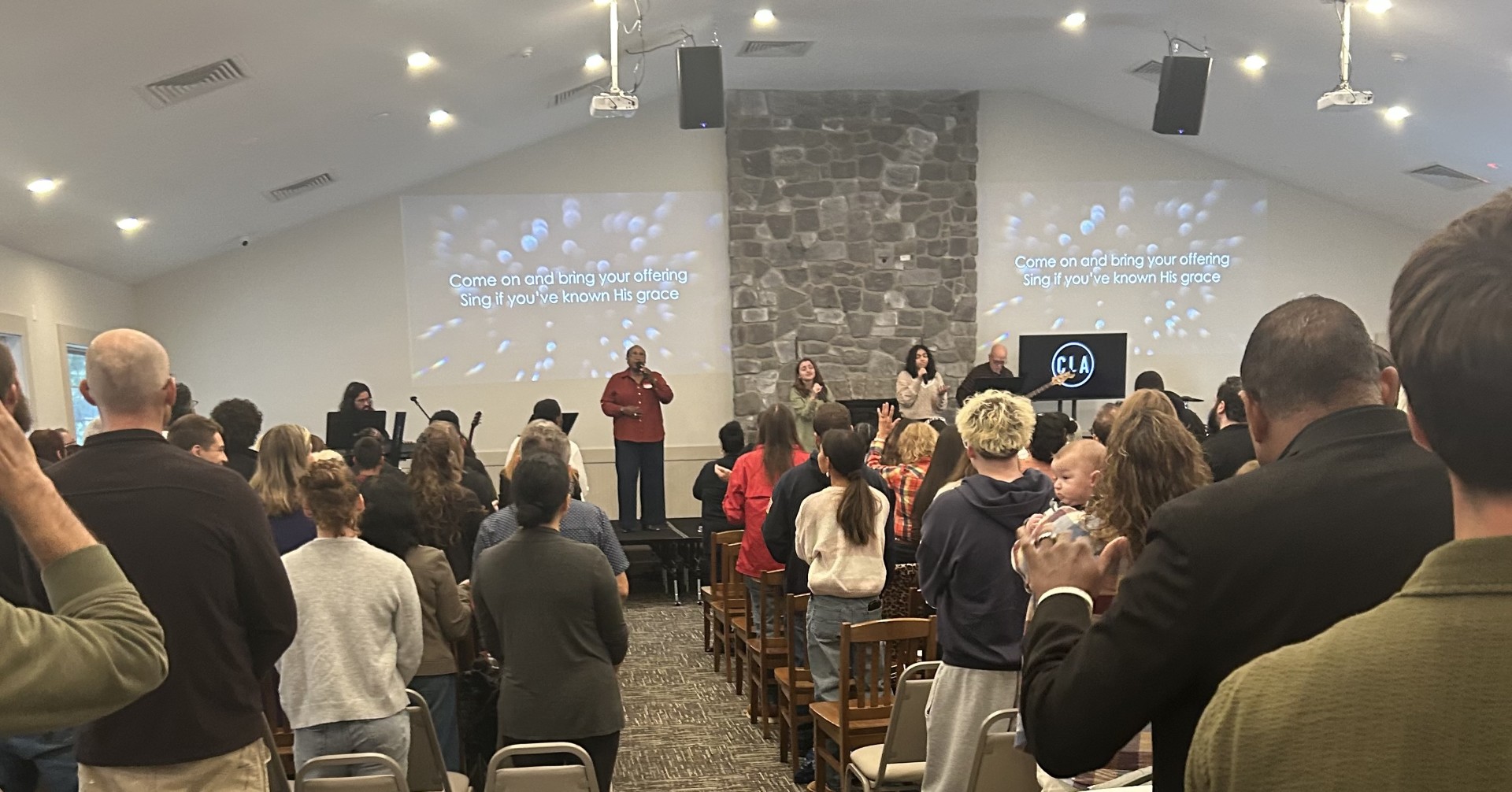 A crowd of people faces forwards toward Pastor Craig at a worship service attended by Sen. Rosemary Brown at the brand-new Christian Life Assemble in Middle Smithfield Township.